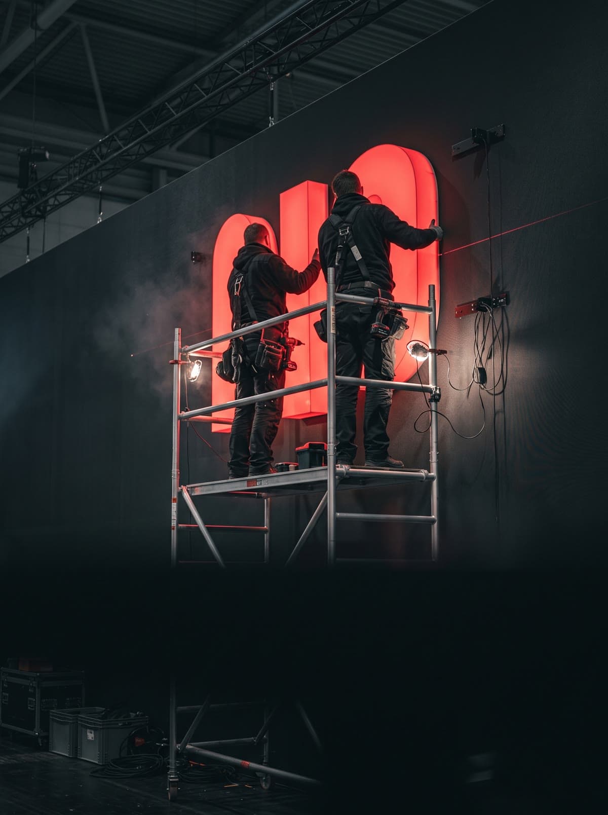 Technicians installing an illuminated element on an exhibition wall